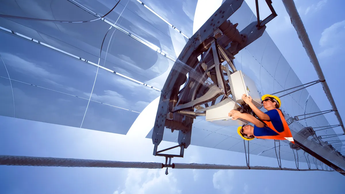 A worker inspecting parabolic mirrors manufactured by Siemens.