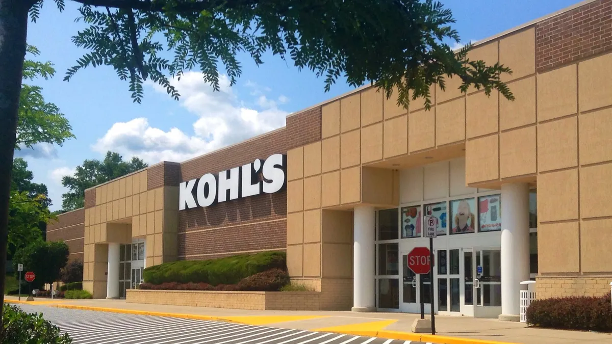 A tree branch frames a Kohl's store on a sunny day.