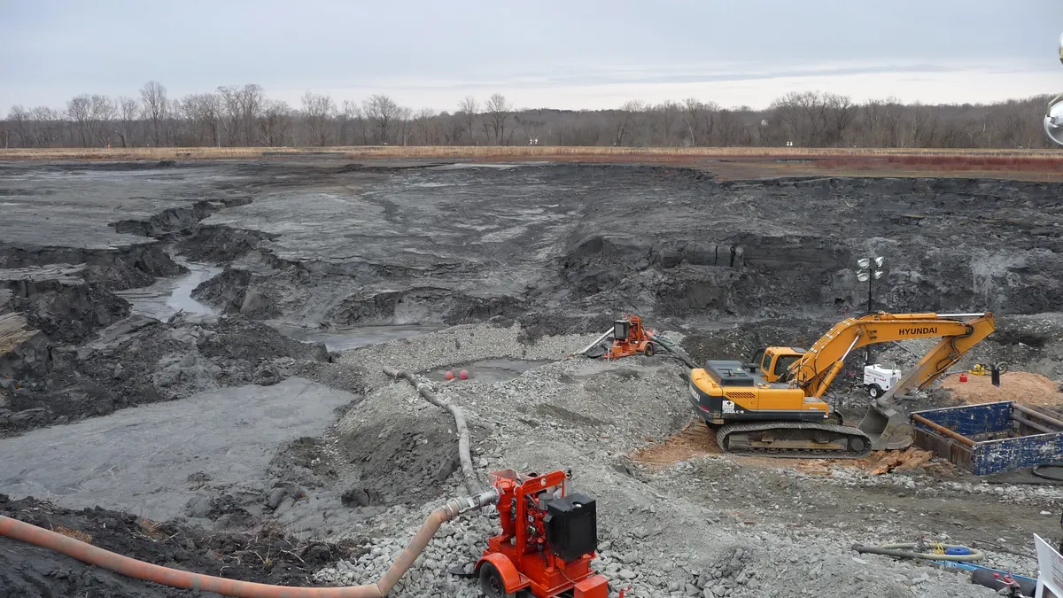 Heavy equipment moves material in a pit.