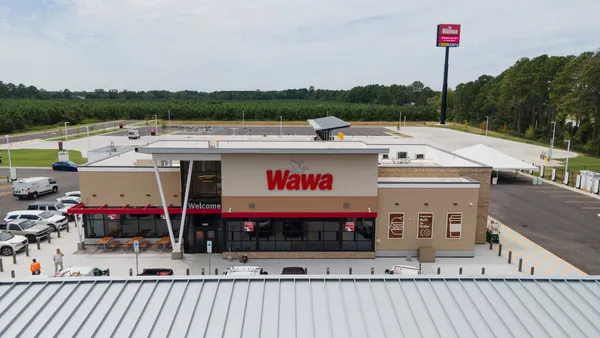A photo of the exterior of a travel center. A sign above the door says Wawa.