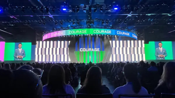 The word "courage" flashes on stage as SHRM's Johnny Taylor speaks at SHRM26 in Orlando, Fla.
