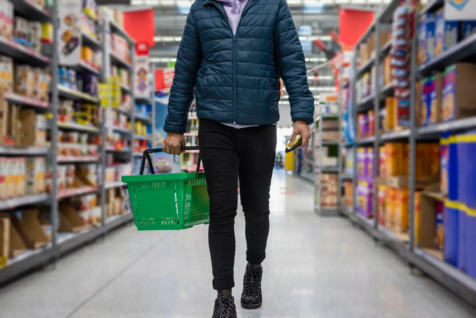 Low angle selected focus view of a person shopping in a supermarket while on a budget.