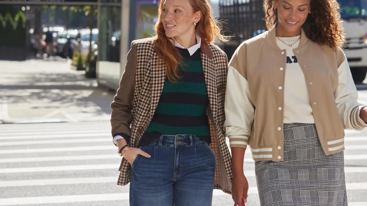 Two women strolling down a crosswalk smiling