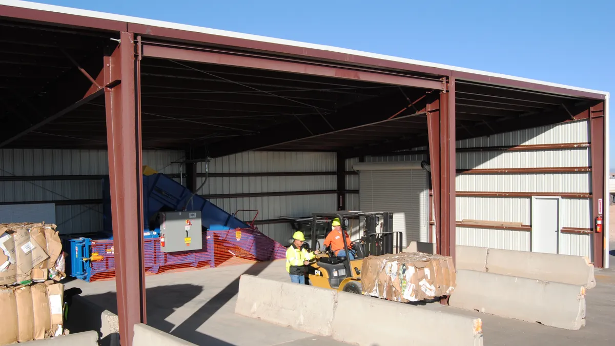 Two people in safety gear at an outdoor recycling facility in New Mexico