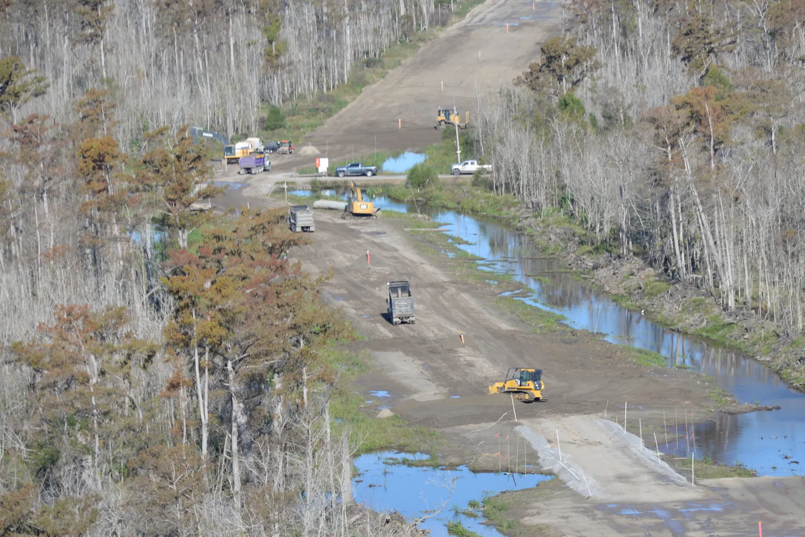 Aerial view of yellow construction equipment in a forested jobsite.