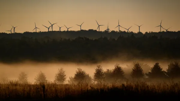 Wind turbines above the horizon at dawn