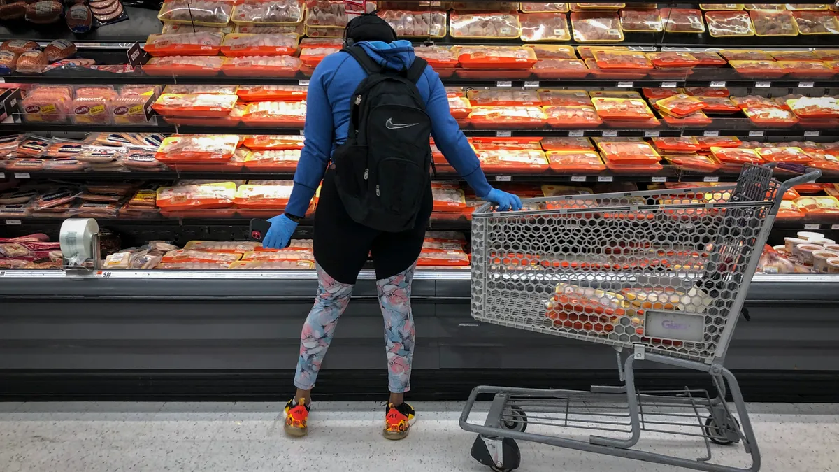 A woman shops for chicken at a grocery store in April 2020.