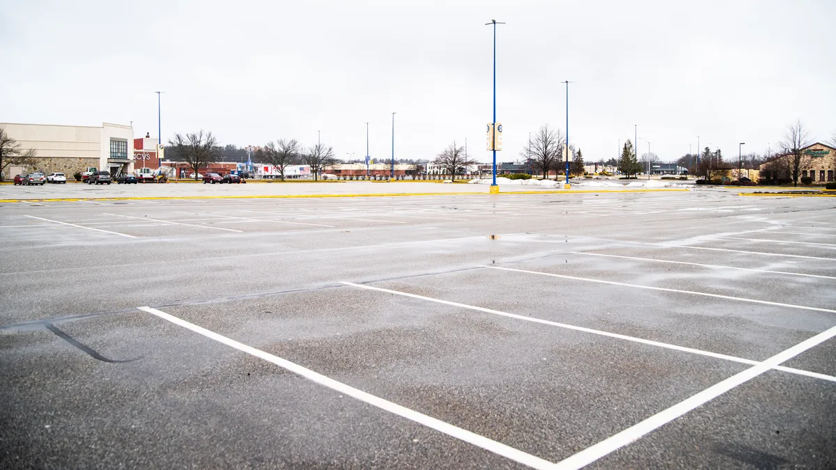 A mall parking lot in South Portland, Maine, is mostly devoid of cars as the COVID-19 pandemic forces most retailers to close.