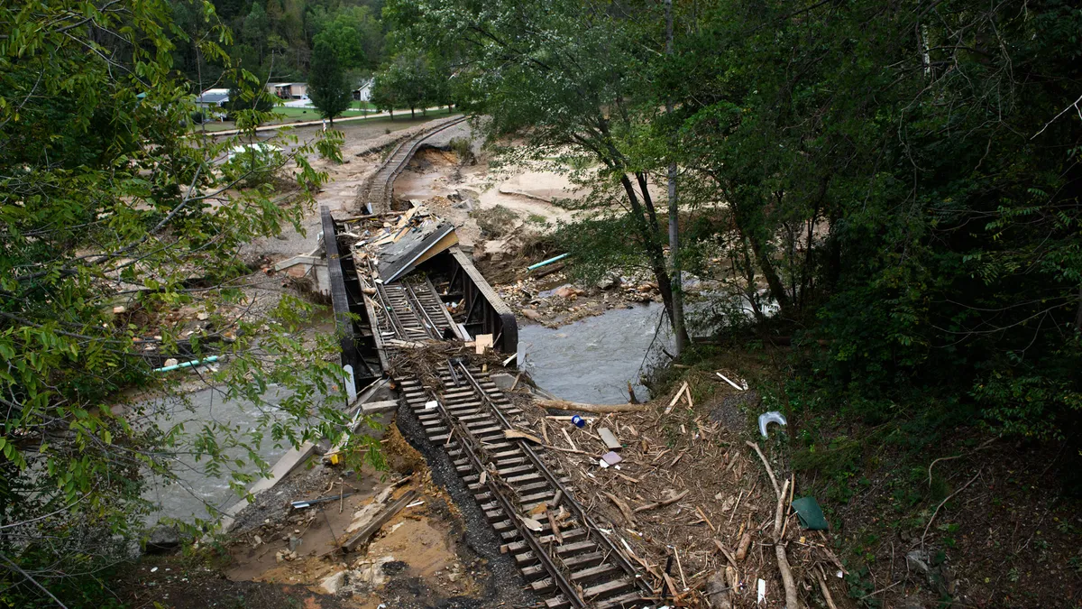 An image of destroyed train tracks running over a damaged bridge in Old Fort, North Carolina, following Hurricane Helene.