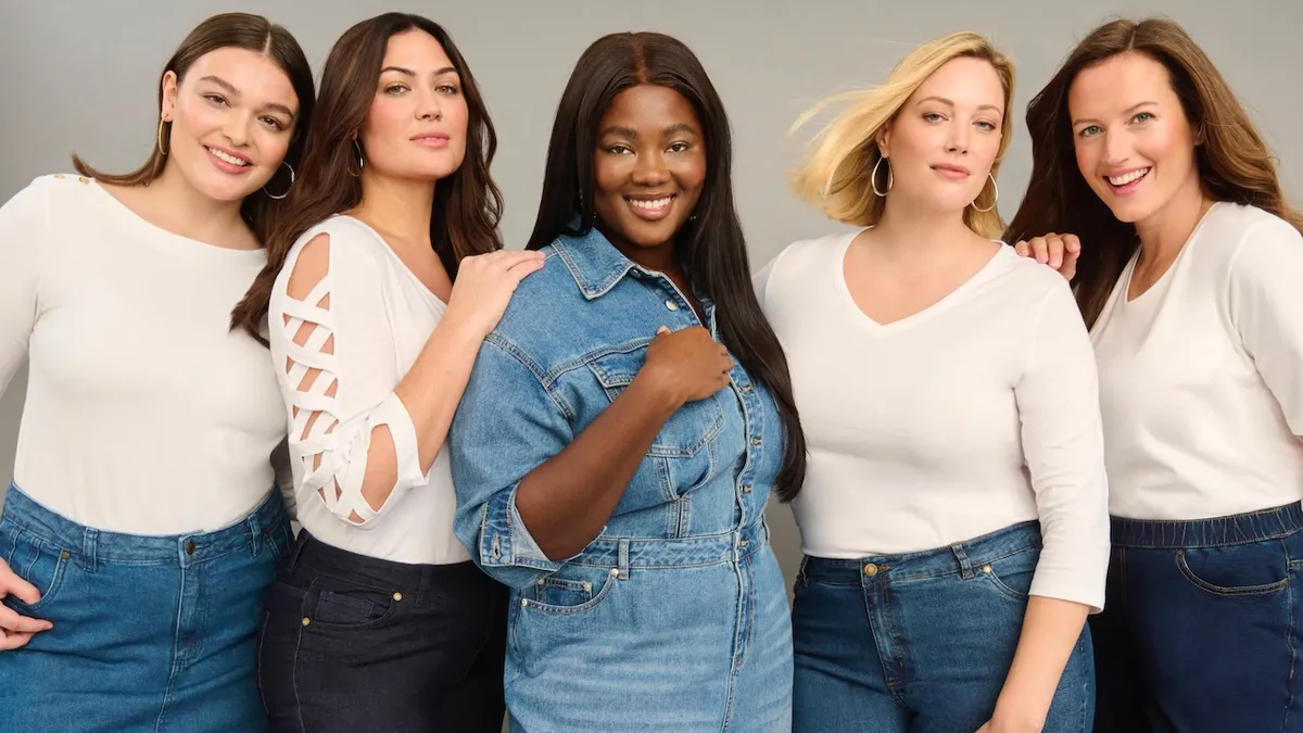 A diverse group of smiling people wearing denim and white.