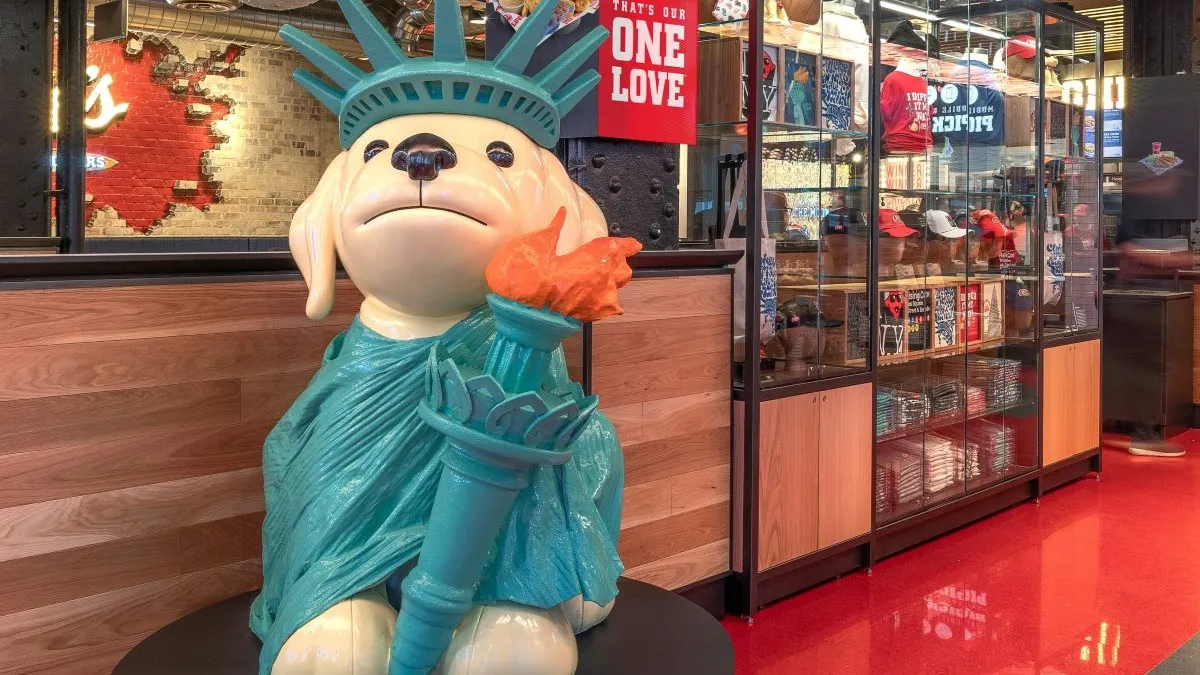 An image of Raising Cane's dog mascot dressed as the Statue of Liberty.