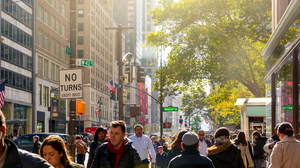 Crowds of people walk on a city street