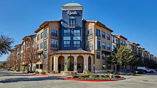 The entrance to a three-level brown brick apartment community.