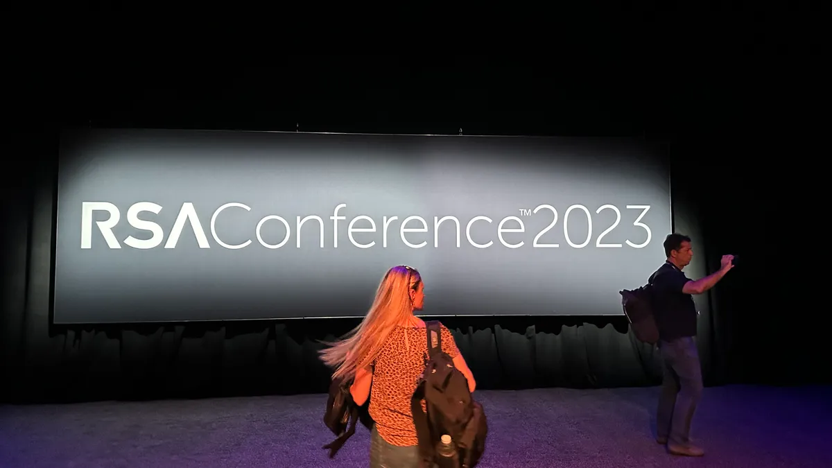 People walk past a sign for RSA Conference 2023