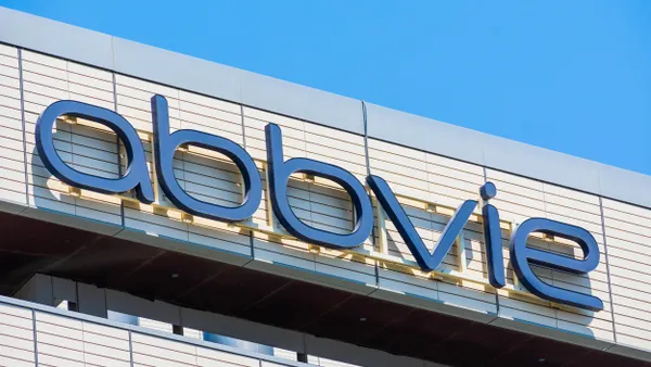 The AbbVie logo is prominently displayed on the facade of a sleek, contemporary building surrounded by a clear blue sky. 