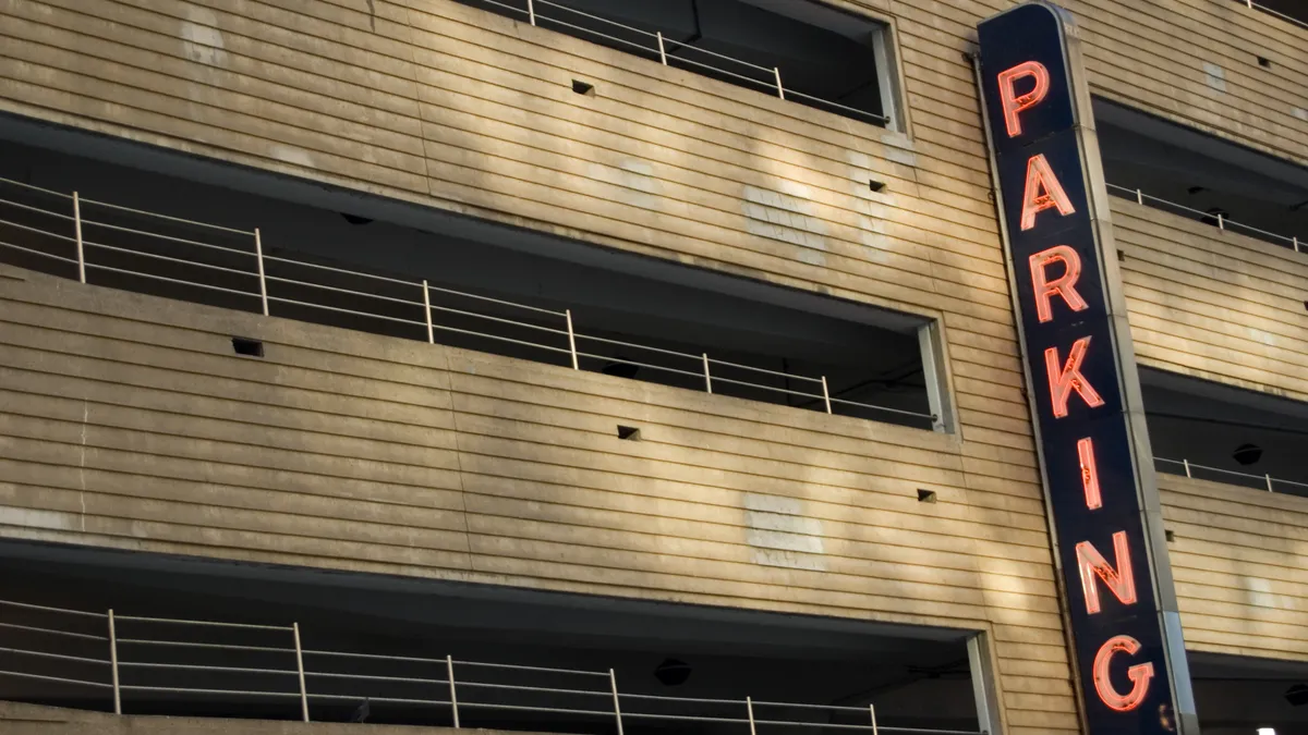 A multi-level parking garage with a neon parking sign in New York City.