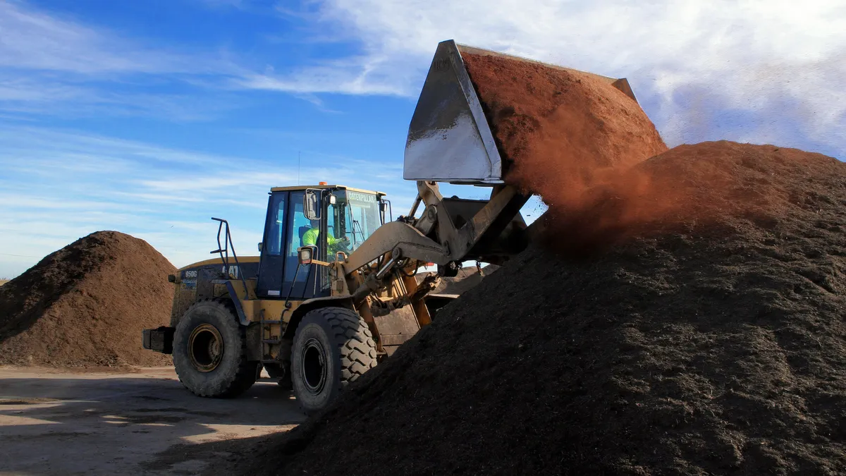 A loader manages compost at a Recology facility