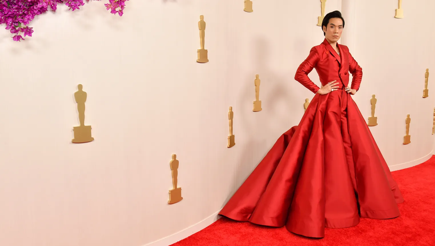 Eugene Lee Yang wears a red ballgown skirt and cropped jacket.