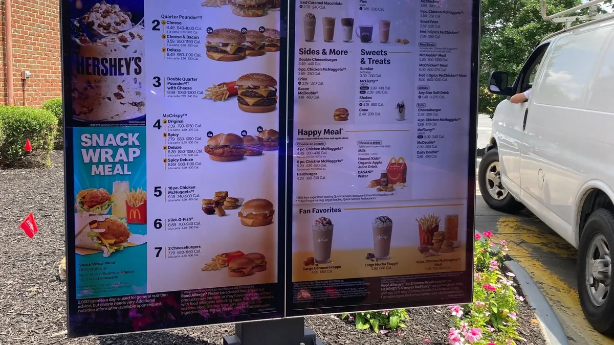 A photograph of a digital menu board at McDonald's with various meal options.