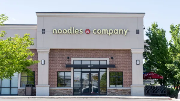 An image of while building with a brick facade and a logo that says "Noodles & Company."