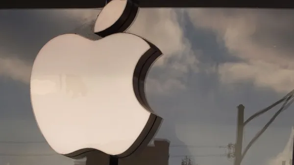 Apple logo hangs above an Apple retail store.