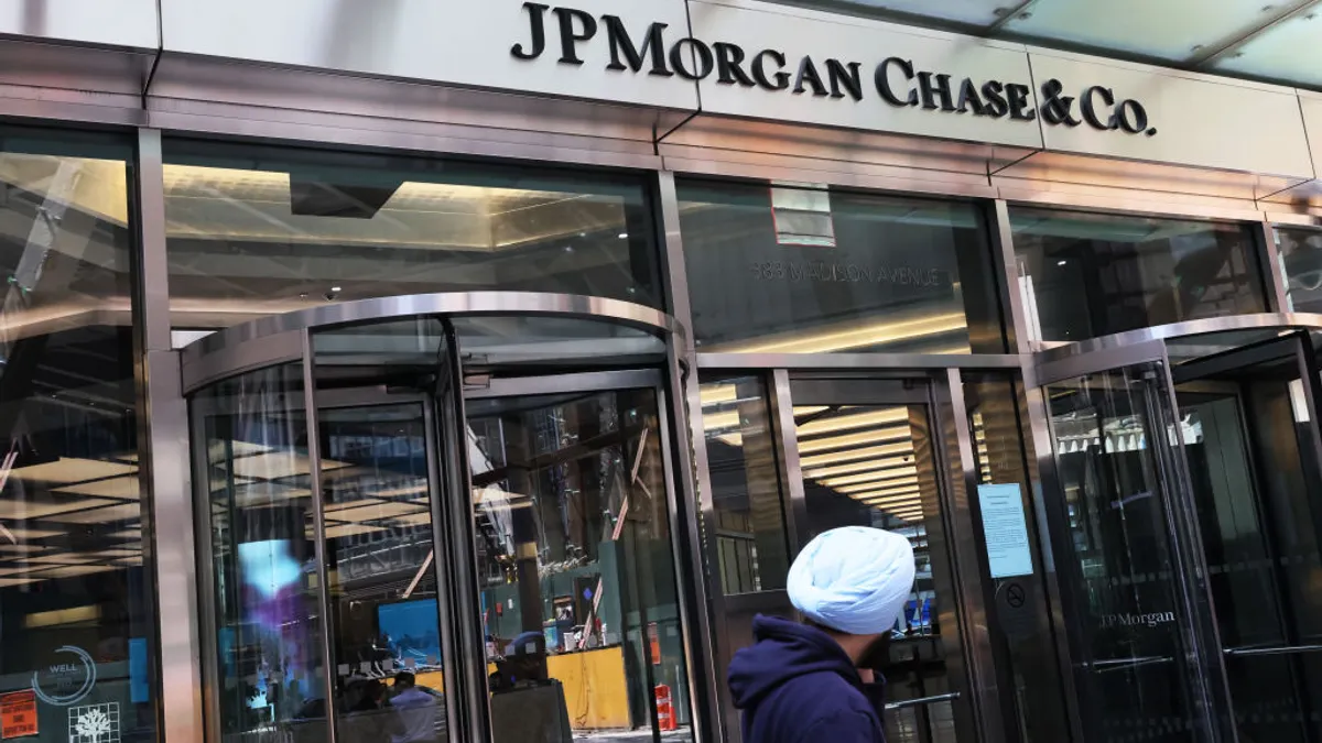 An entrance to a Madison Avenue JPMorgan Chase building is shown, with revolving doors and a person walking in the foreground.