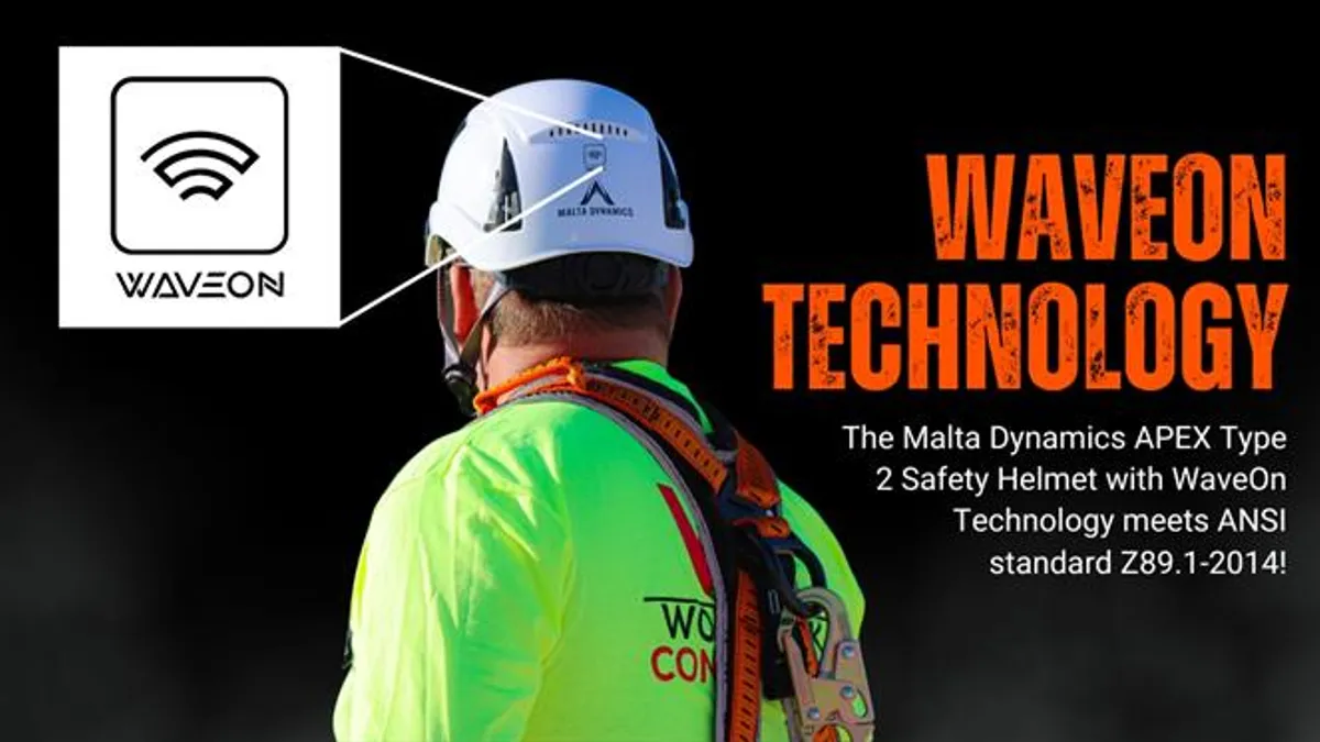 A construction worker in a green shirt with a protective safety helmet that incorporates wave technology