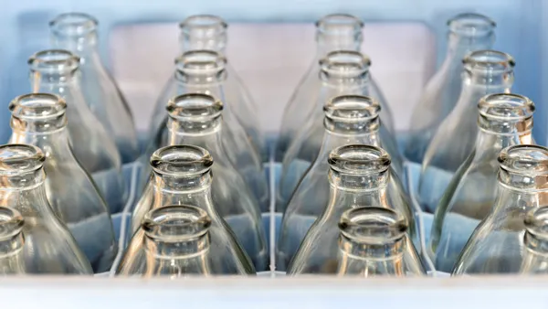 closeup of tops of glass bottles lined up in a crate