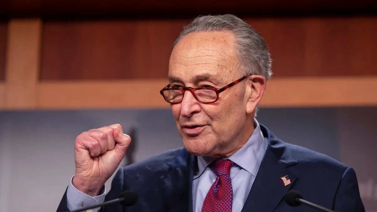 Senate Majority Leader Chuck Schumer speaks at a podium