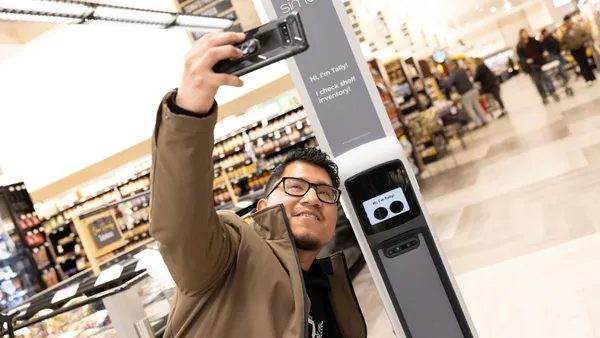 A person taking a selfie with an in-store robot.