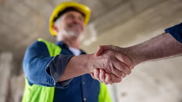 a closeup view of a man in a hard hat shaking hands