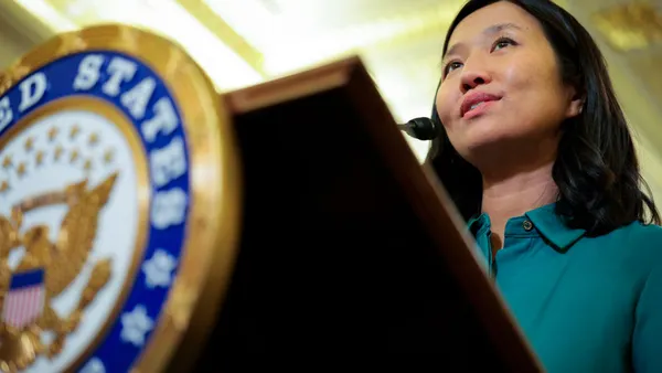 Close up view of a woman speaking behind a podium.
