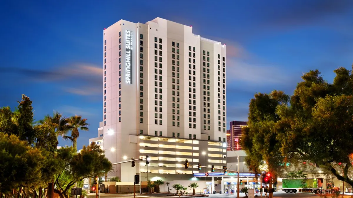 The exterior of the hotel as seen from across a street intersection at night.