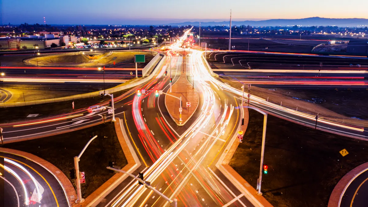 Lights from traffic blur together in this aerial photograph showing a double-diamond interchange in Manteca, California, at night.