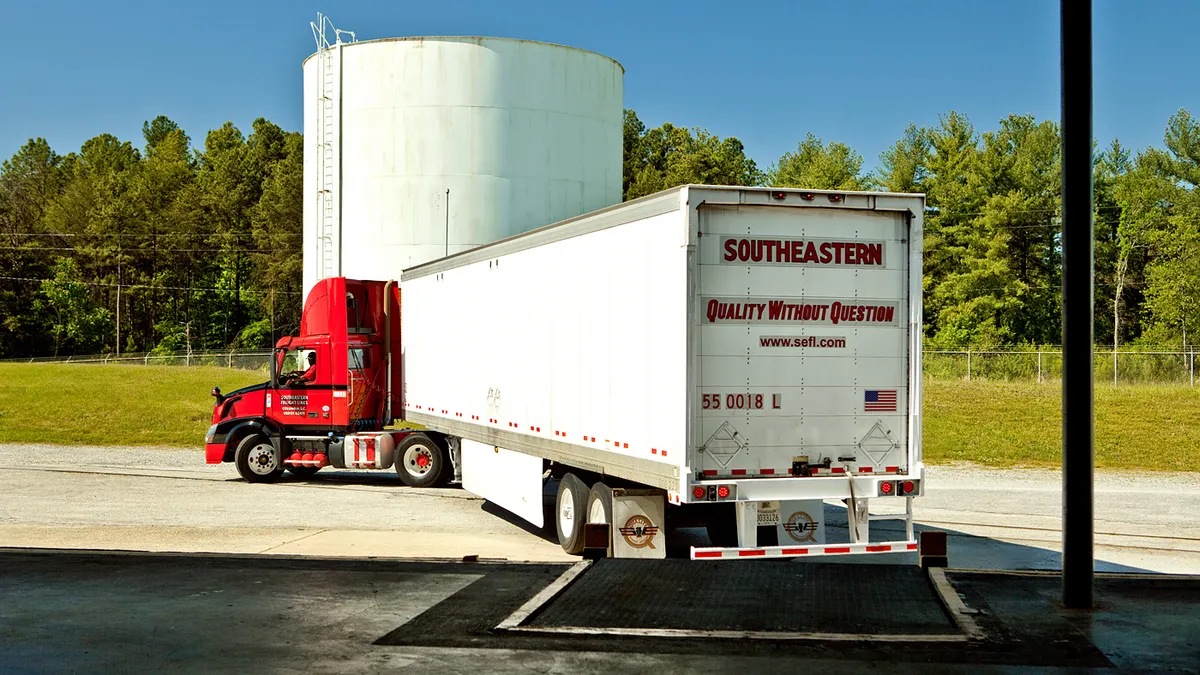 The back of a freight truck pulling out of a warehouse.