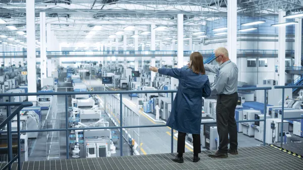 Experienced Male and Female Engineers Standing on a Platform with Their Back to Camera