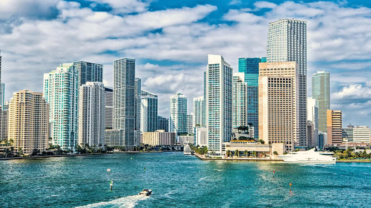 iami skyline. Yachts sail on sea water to city - stock photo.