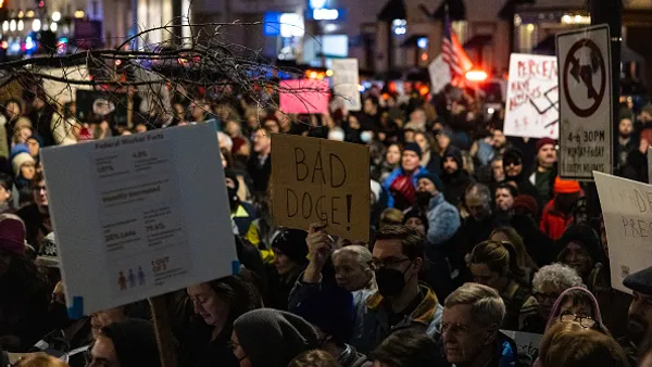 Demonstrators with signs rally in front of the U.S. Treasury department.