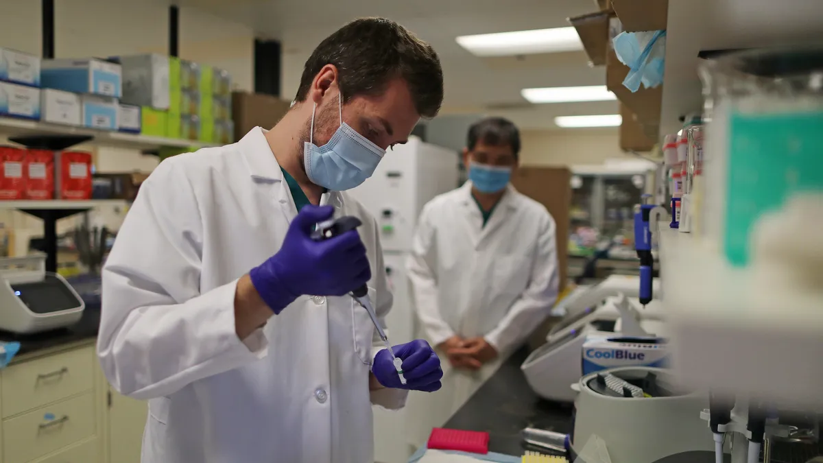 Lab Technician  prepares a solution that will be used to process coronavirus test samples