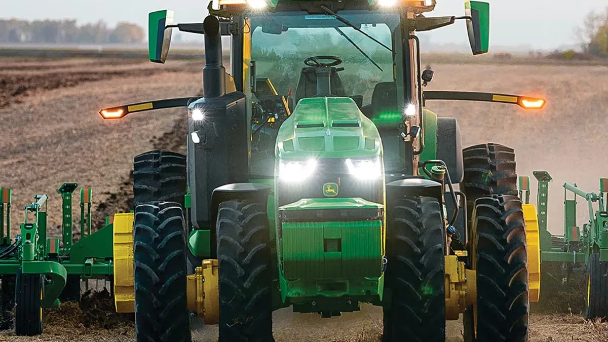 A Deere tractor is seen running without a person in the driver's seat