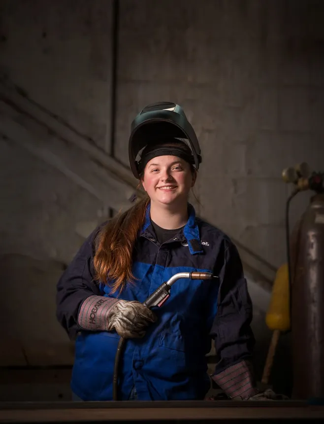 A person in welding gear at a GE Appliances facility