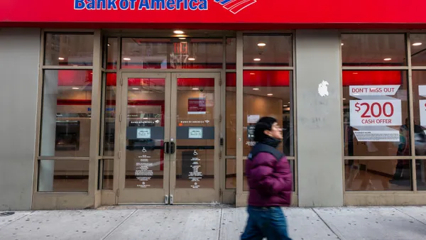 A person walks by a Bank of America branch location