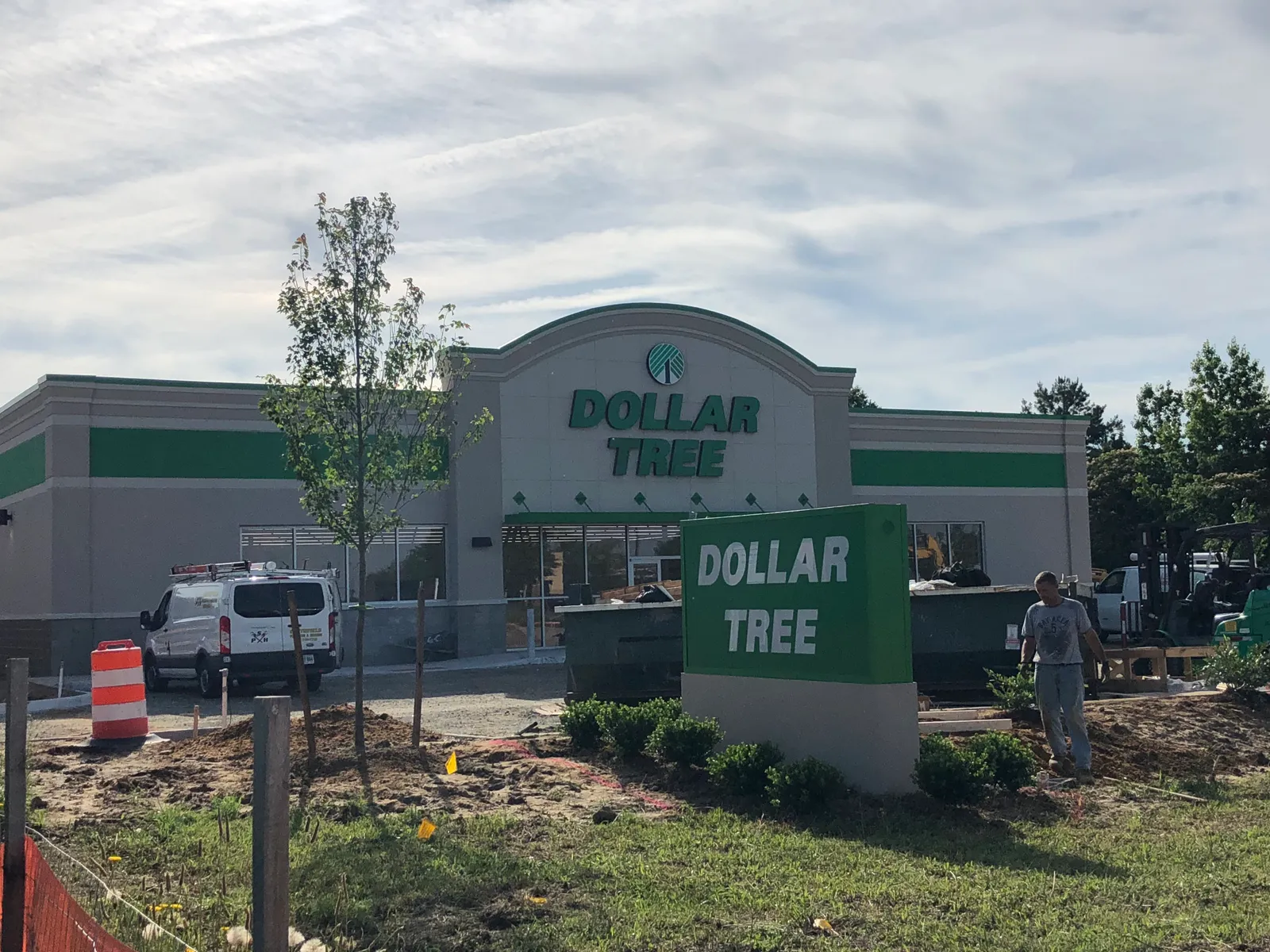 The exterior of a newly constructed Dollar Tree store with the company's signature green color scheme with a blue sky