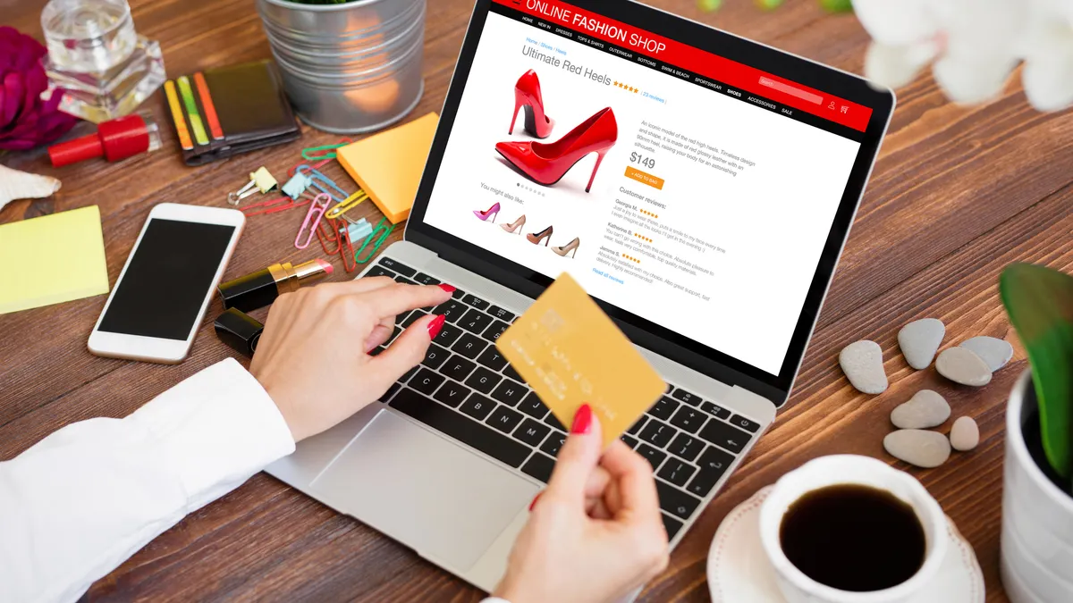 Woman ordering new high heel shoes in online shop and paying for purchase by credit card.