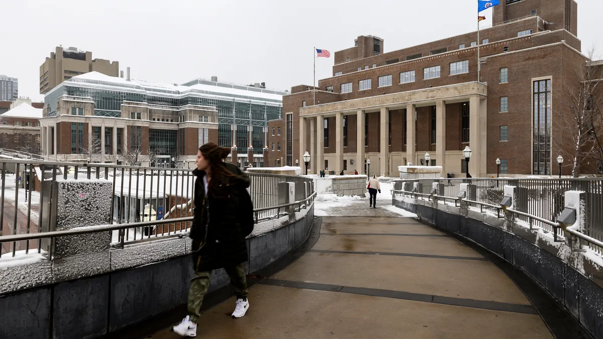 Snow sits in front of a brick building.