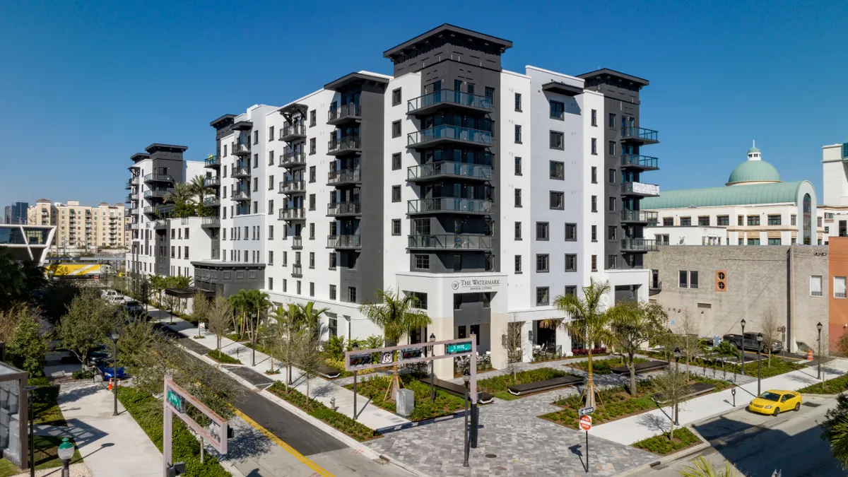 Aerial view of ew, modern white and black, eight-story apartment building.