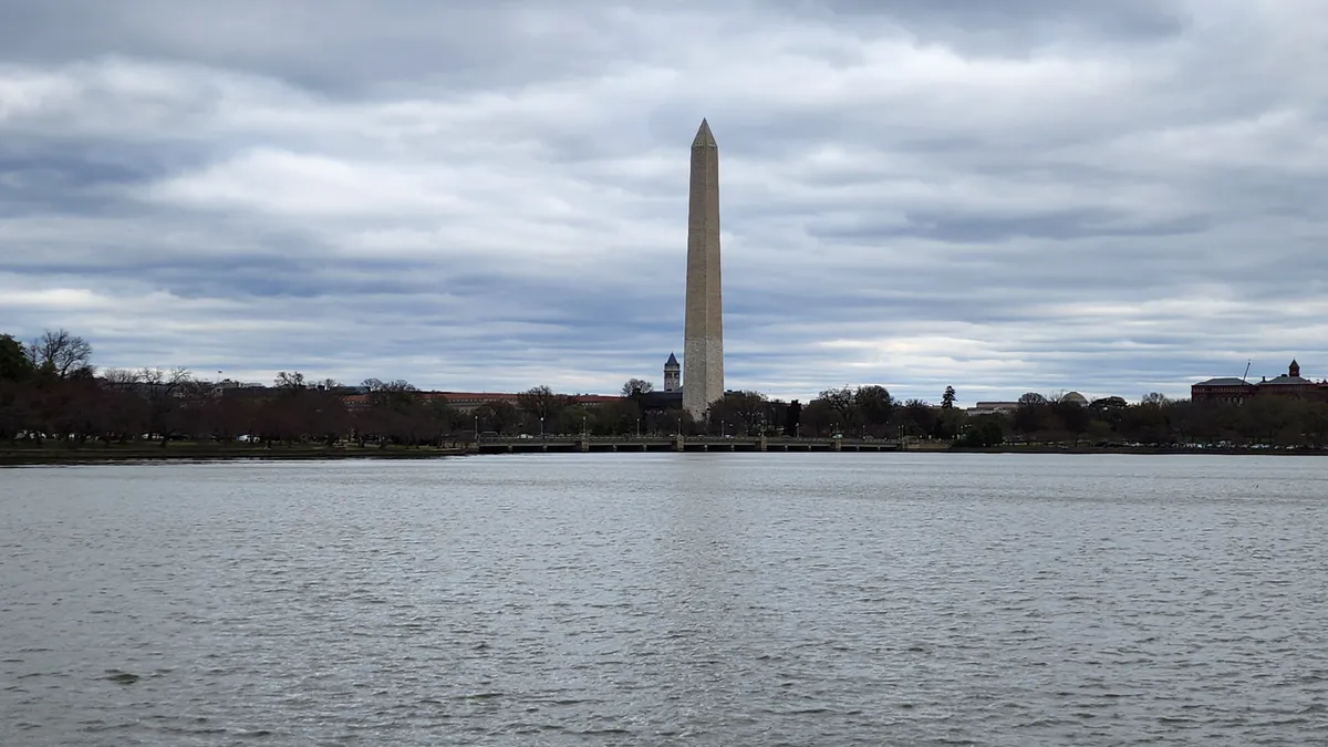 The Tidal Basin in Washington, D.C. with the monument in the background on a cloudy day.