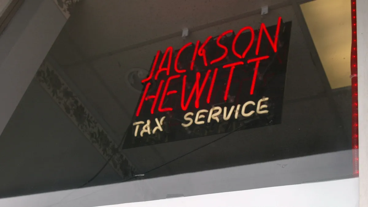 A neon Jackson Hewitt sign in red.