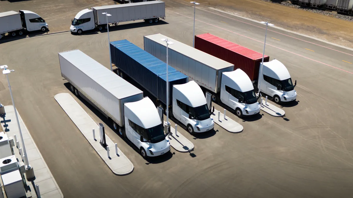 A photo of 18 wheelers at a truck charging station.