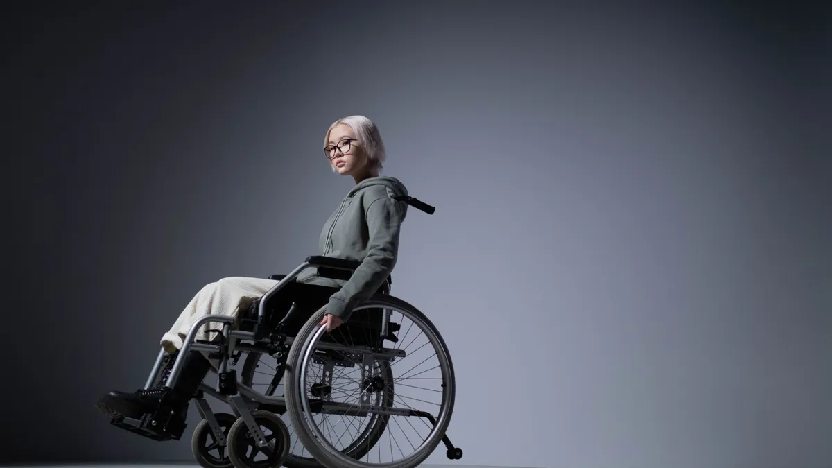 An Asian Gen Zer sits for a portrait in their wheelchair